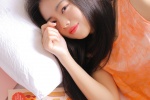 Seductive and seductive photo of beautiful woman in orange nightgown on bed