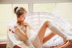 Seductive photo of beautiful lady in white silk stockings with sexy legs
