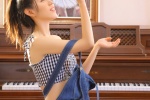 Sexy photo of a beautiful woman with a slim waist next to the piano