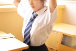 Seductive photo of beauty in British style uniform at classroom desk